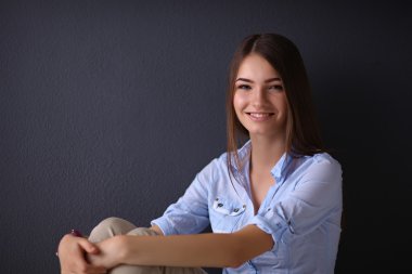 katta oturan genç kadın izole koyu arka plan