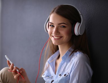 katta oturan kulaklıklar ile gülümseyen kız