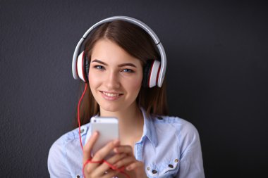 gri arka plan üzerinde izole kulaklık ile gülümseyen kız