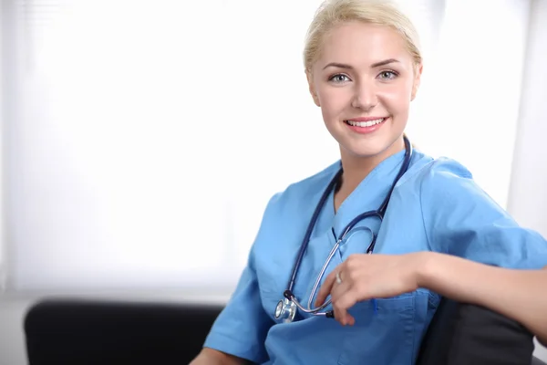 Retrato de un joven médico feliz sentado en el sofá — Foto de Stock