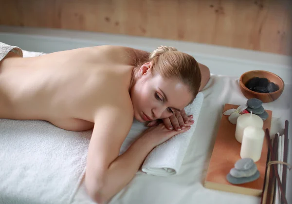 Красивая молодая женщина получает спа-массаж, лежа в салоне — стоковое фото