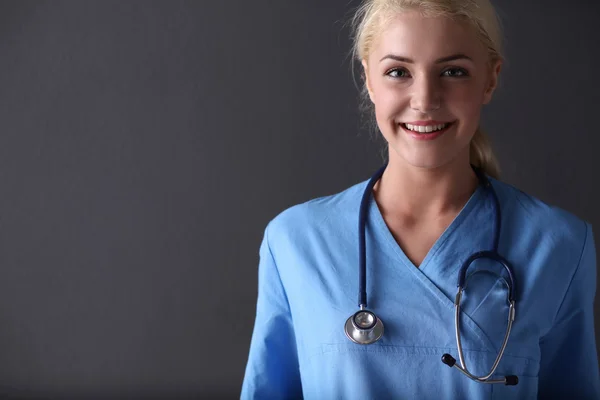 Nuori lääkäri nainen stetoskooppi eristetty harmaalla taustalla — kuvapankkivalokuva
