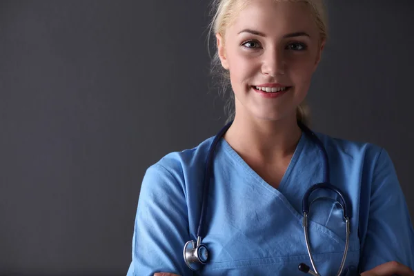 Jovem médica com estetoscópio isolado em fundo cinza — Fotografia de Stock