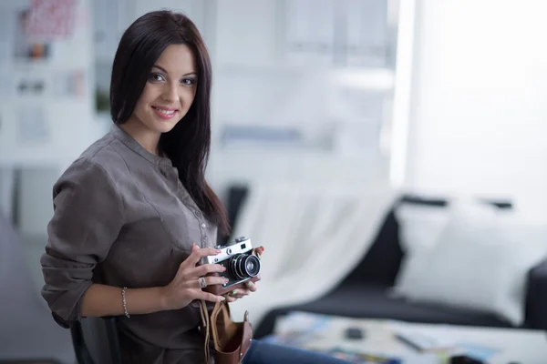 Vrouw is een proffessional fotograaf met camera in office — Stockfoto