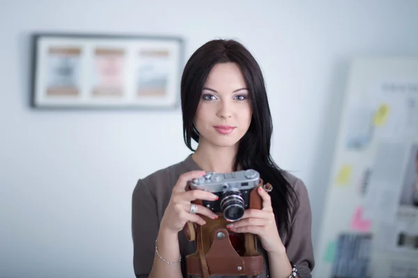 Mujer es una fotógrafa profesional con cámara en la oficina — Foto de Stock