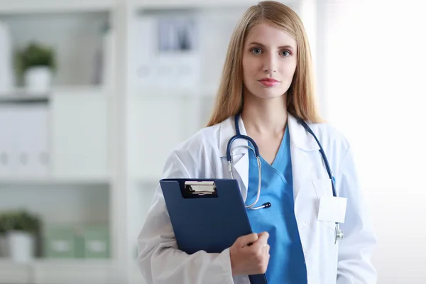 Kobieta lekarz stoi blisko okna z folderu — Zdjęcie stockowe