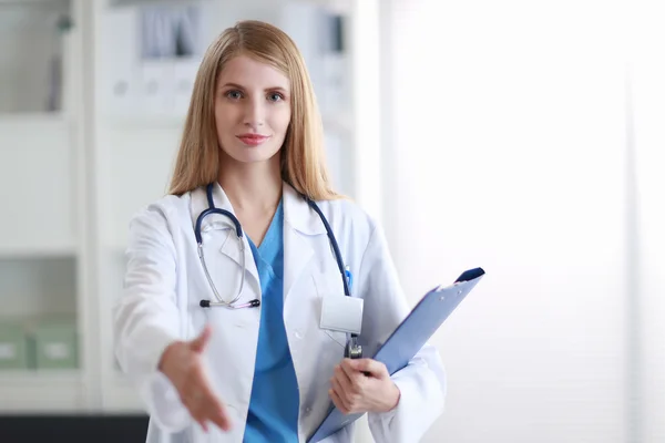 Portrait of a young female doctor giving hand — Stock Photo, Image