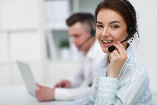 Zakenvrouw met headset glimlachen op camera in callcenter — Stockfoto