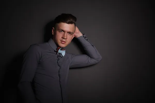 Podobizna mladého muže stojící, izolovaných na šedém pozadí — Stock fotografie