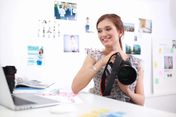 年轻的女摄影师加工坐在桌子上的照片 — 图库照片