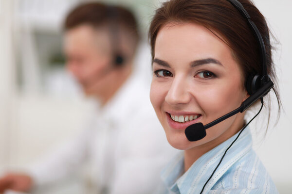 Businesswoman with headset smiling at camera in call center