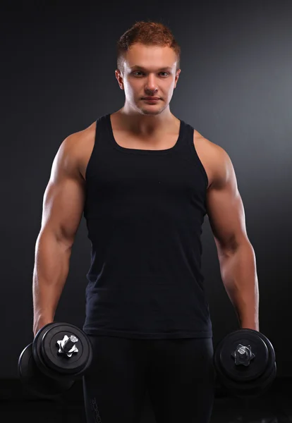 Uomo muscoloso in forma che si esercita con manubri — Foto Stock
