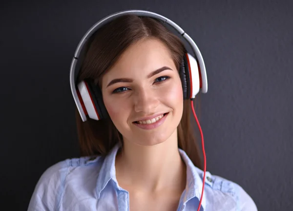 Ragazza sorridente con cuffie isolate su sfondo grigio — Foto Stock