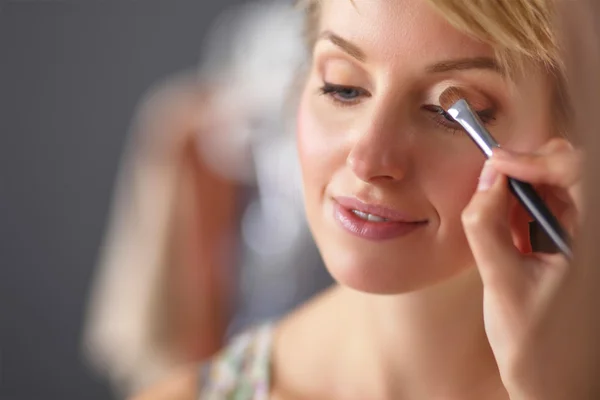 Künstlerin macht professionelles Make-up für Frauen — Stockfoto