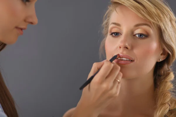 Künstlerin macht professionelles Make-up für Frauen — Stockfoto