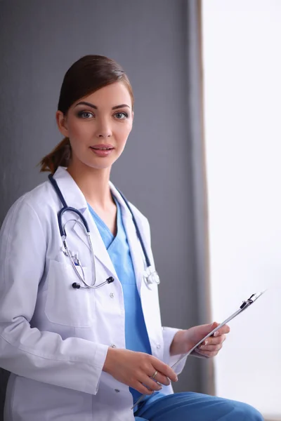 Krankenschwester hält Ordner und macht Notizen - isoliert auf grauem Backgr — Stockfoto