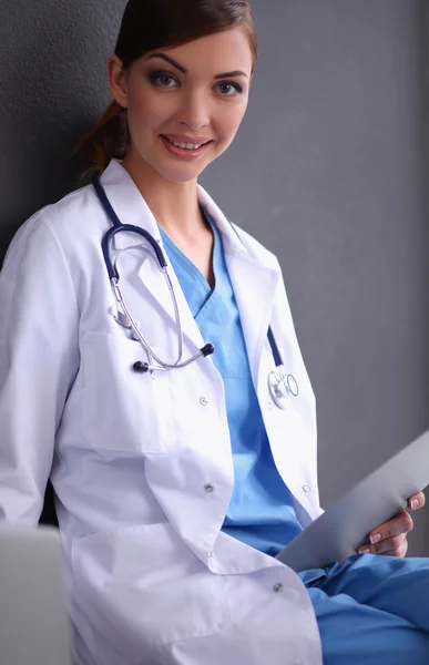 Vrouwelijke arts werken geïsoleerd op grijze achtergrond — Stockfoto