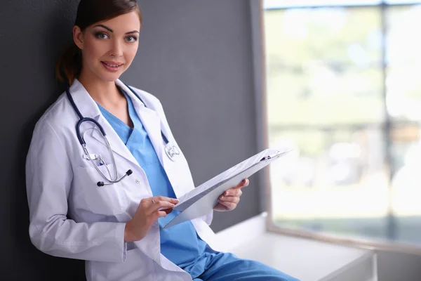 Nurse holding folder and taking notes - isolated on grey backgr — Stock Photo, Image