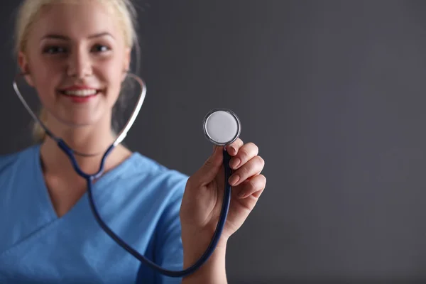 Kvinnliga läkare med stetoskop lyssna, isolerad på grå ba — Stockfoto