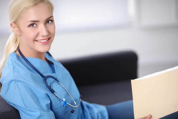 Portrait d'un jeune médecin heureux assis sur le canapé avec pli — Photo