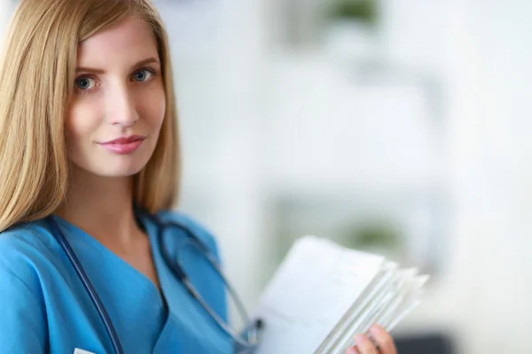 Portrait of woman doctor with folder at hospital corridor — Stock Photo, Image