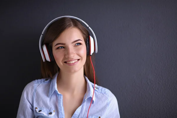 Menina sorridente com fones de ouvido isolados em fundo cinza — Fotografia de Stock