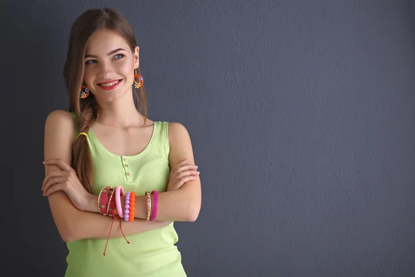 Jonge vrouw zittend op de vloer geïsoleerd donkere achtergrond — Stockfoto