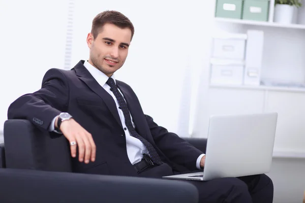Businessman sitting on sofa in the office — Stock Photo, Image
