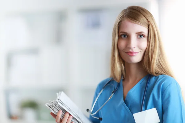 Portrait of woman doctor with folder at hospital corridor — Stock Photo, Image