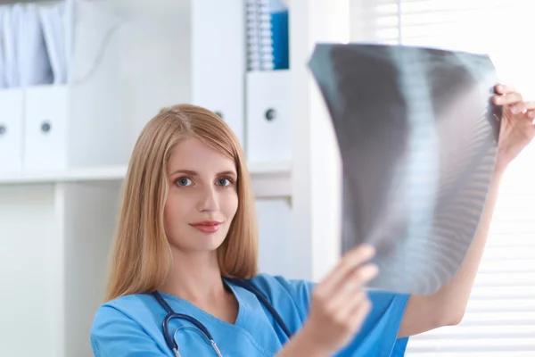 Young female doctor looking at the x-ray picture — Stock Photo, Image