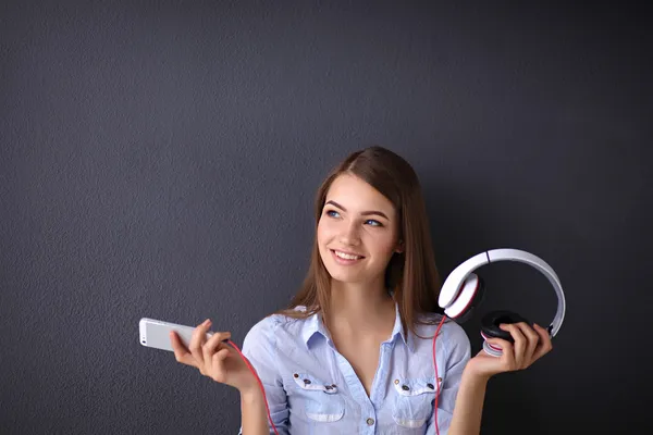 Menina sorridente com fones de ouvido isolados em fundo cinza — Fotografia de Stock