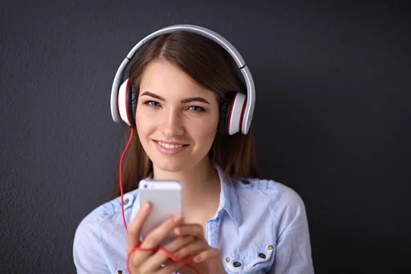 Lachende meisje met hoofdtelefoon geïsoleerd op grijze achtergrond — Stockfoto