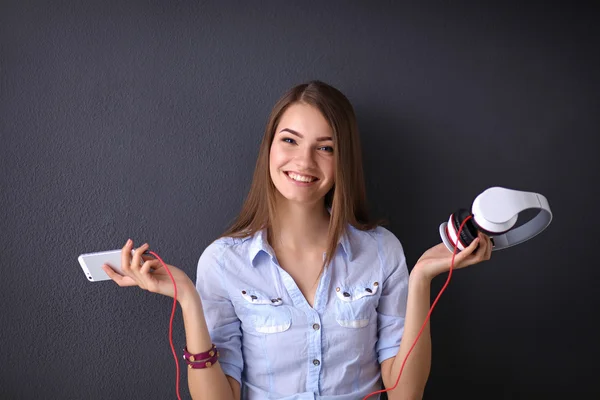 Ragazza sorridente con cuffie isolate su sfondo grigio — Foto Stock