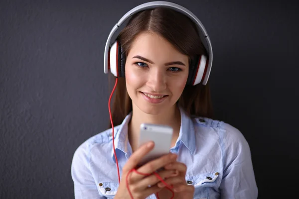 Lachende meisje met hoofdtelefoon geïsoleerd op grijze achtergrond — Stockfoto