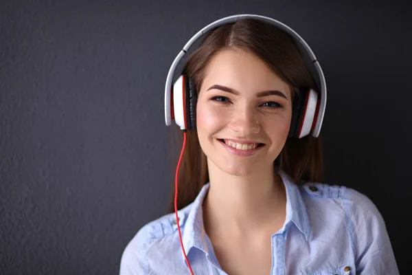 Lachende meisje met hoofdtelefoon geïsoleerd op grijze achtergrond — Stockfoto