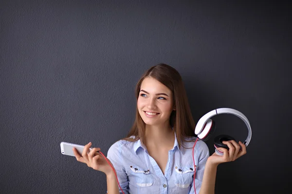 Smiling girl with headphones isolated on grey background — Stock Photo, Image