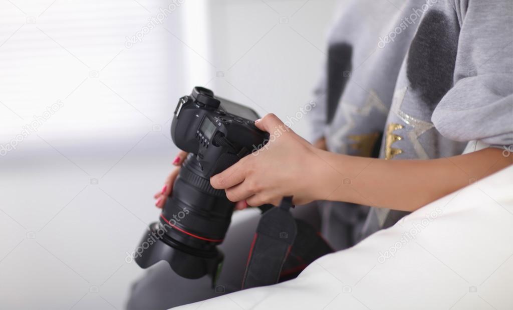 Woman sitting on a sofa in her house with camera