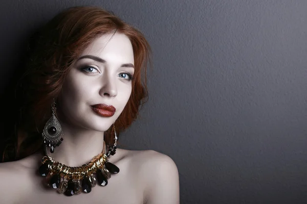 Young beautiful brunette woman in ear-rings, beads — Stock Photo, Image