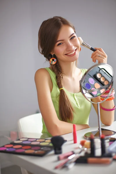 Ung vacker kvinna gör make-up nära spegeln — Stockfoto