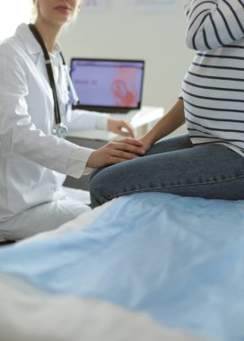 Hastanede doktorla gülümseyen güzel bir hamile kadın.