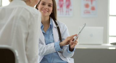 Doktor ve hasta masada otururken bir şey tartışıyorlar. İlaç ve sağlık hizmetleri kavramı