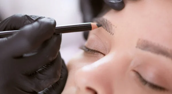 Cosmetologist applying permanent make up on eyebrows — Stock Photo, Image