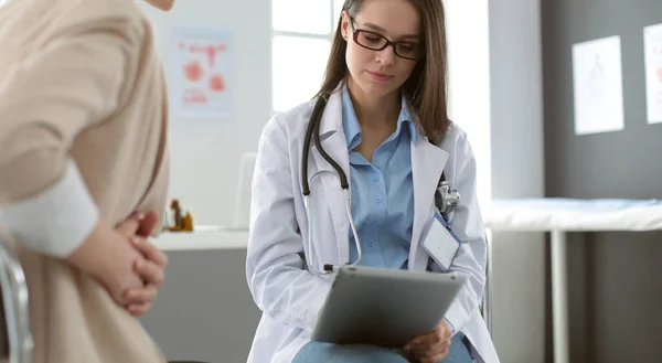 Médico e paciente discutindo algo enquanto se senta na mesa. Conceito de medicina e cuidados de saúde — Fotografia de Stock