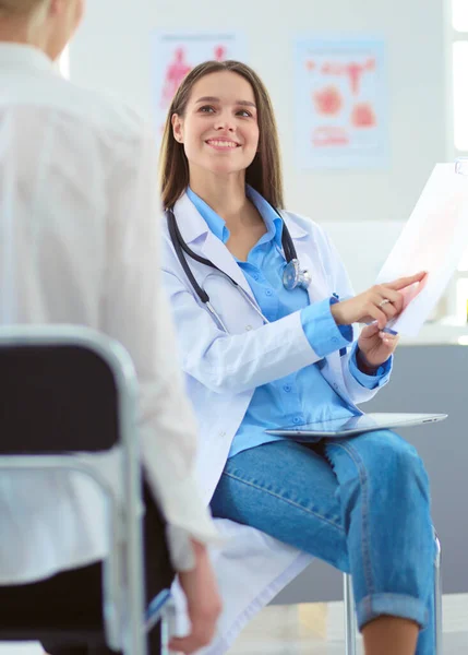 Docteur et patient discutant de quelque chose assis à la table. Médecine et soins de santé concept — Photo