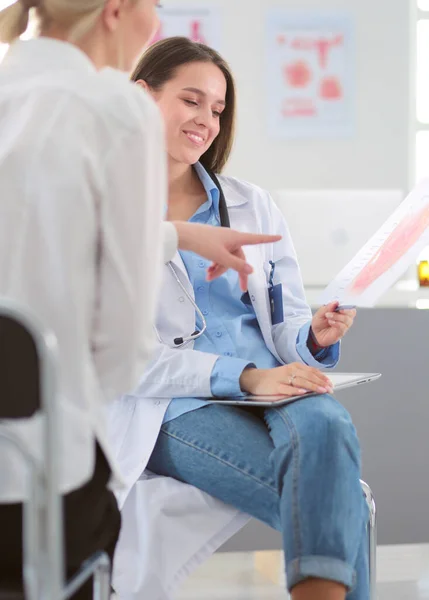 Médico e paciente discutindo algo enquanto se senta na mesa. Conceito de medicina e cuidados de saúde — Fotografia de Stock