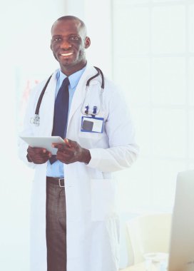 Tablet bilgisayarlı siyahi bir doktor hastanede bekliyor.