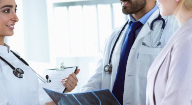 Bayan bir doktor başka bir doktora ofisinde röntgen gösteriyor.