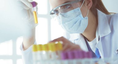 Modern laboratuvar veya hastanede plastik tıbbi tüplerle çalışan araştırmacı, doktor, bilim adamı veya laboratuvar asistanı