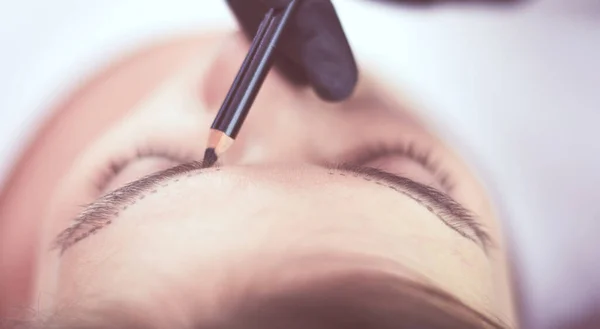 Cosmetologo che applica trucco permanente sulle sopracciglia — Foto Stock