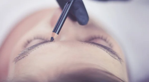 Kosmetikerin schminkt die Augenbrauen dauerhaft — Stockfoto